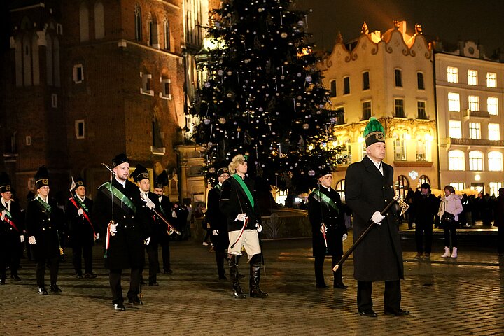 Studenci i Pracownicy w galowych strojach górniczych Barbórka 2024 na tle Kościoła Mariackiego w Krakowie