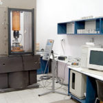 Laboratorium. Po lewej komputery po prawej urządzenie o ściskania próbek.