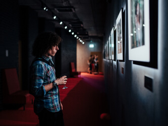 Młody męczyzna obserwuje podświetlony obraz na szarej ścianie.