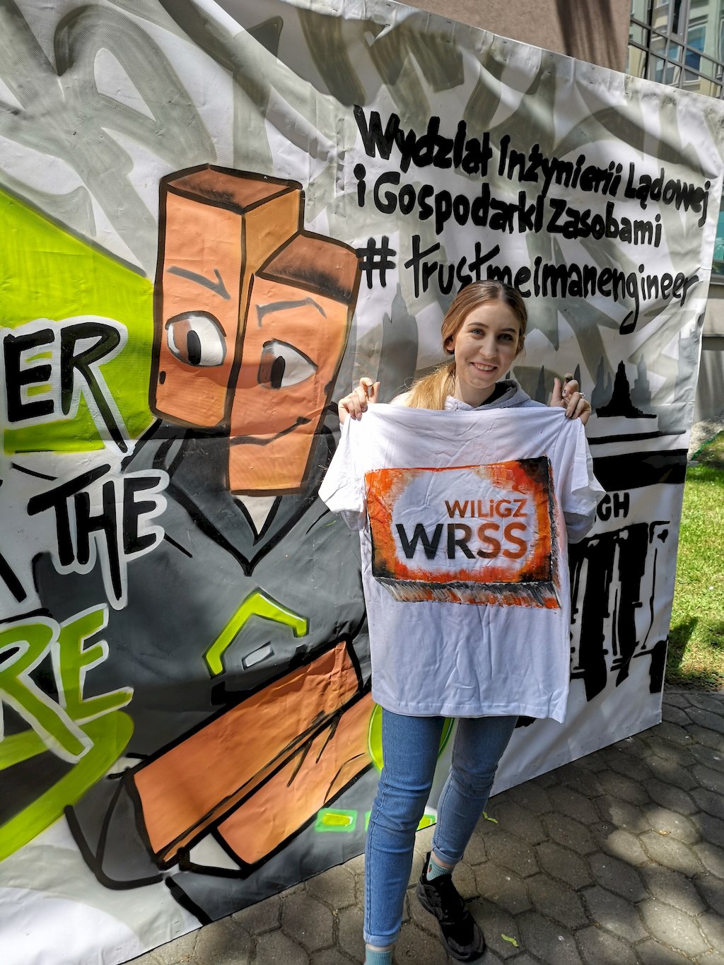 Studentka prezentuje koszulkę z dużym napisem WRSS