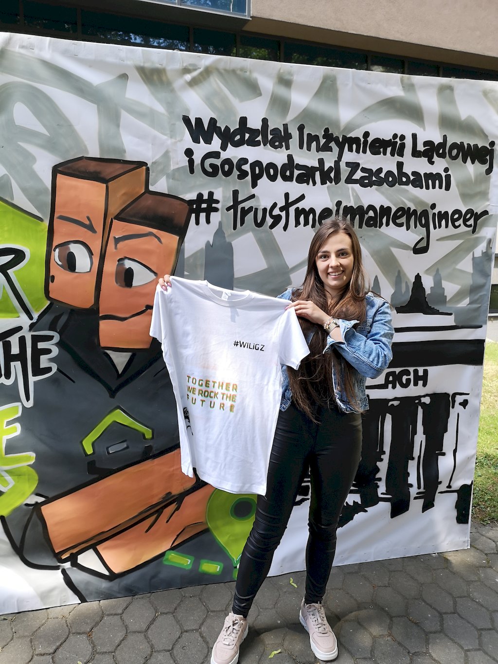 Studentka prezentuje koszulkę z napisem Together we rock the future