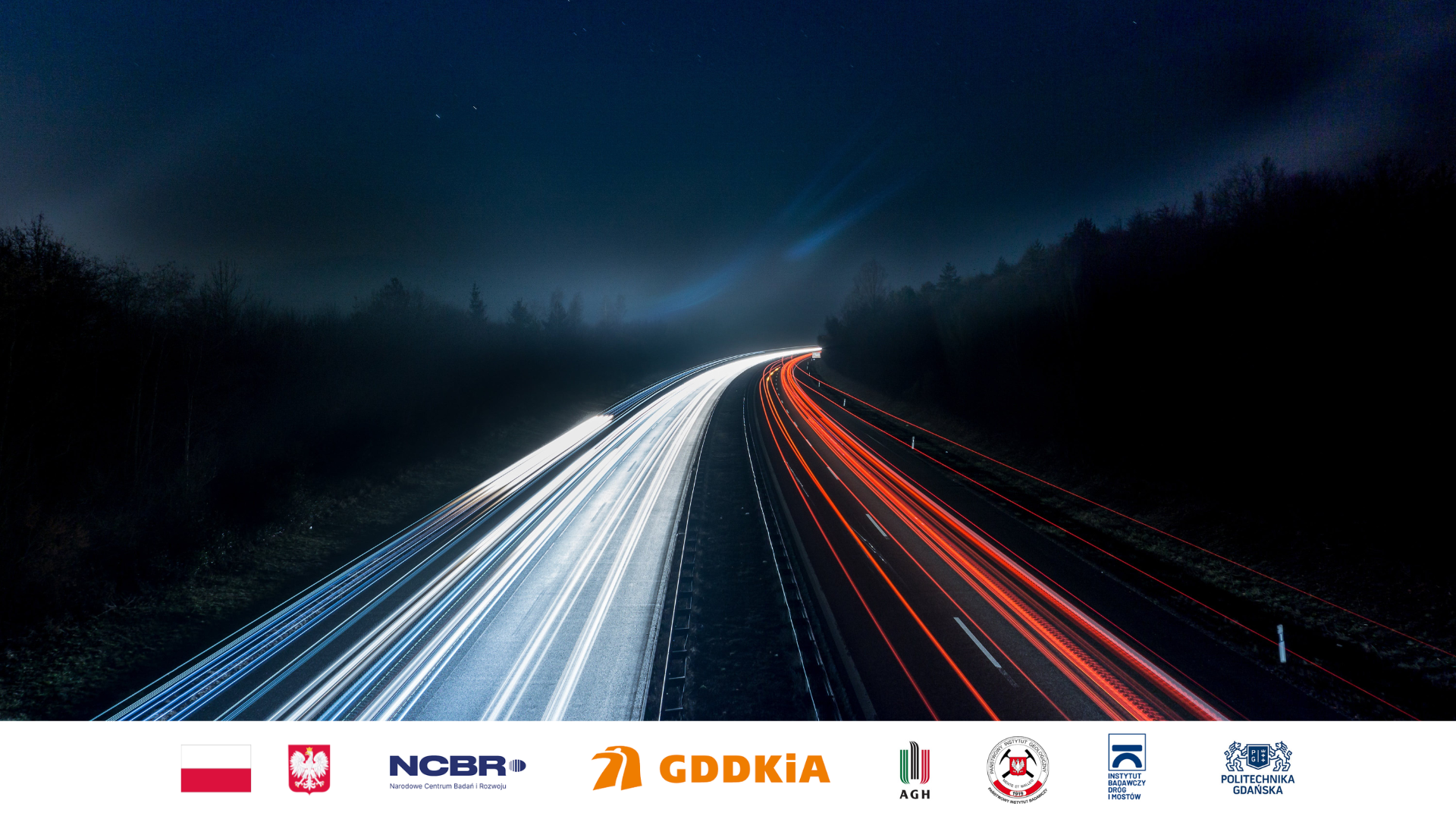 Na zdjęciu widać rozmazane światła samochodów poruszających się nocom po drodze szybkiego ruchu.